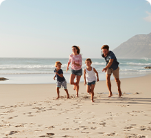 Family running along a beach